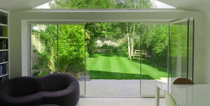 Frameless glass sliding doors bringing the garden inside